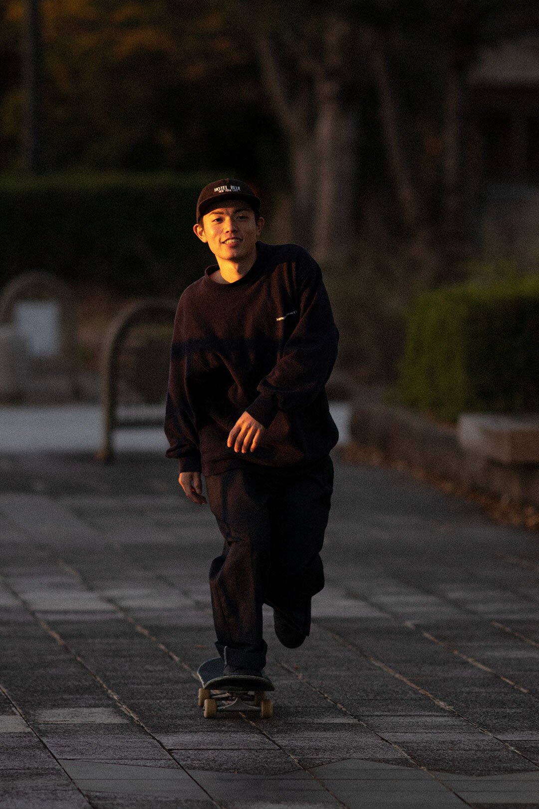 オレンジの夕日に照らされるオールブラックのNIKE SBシューズ